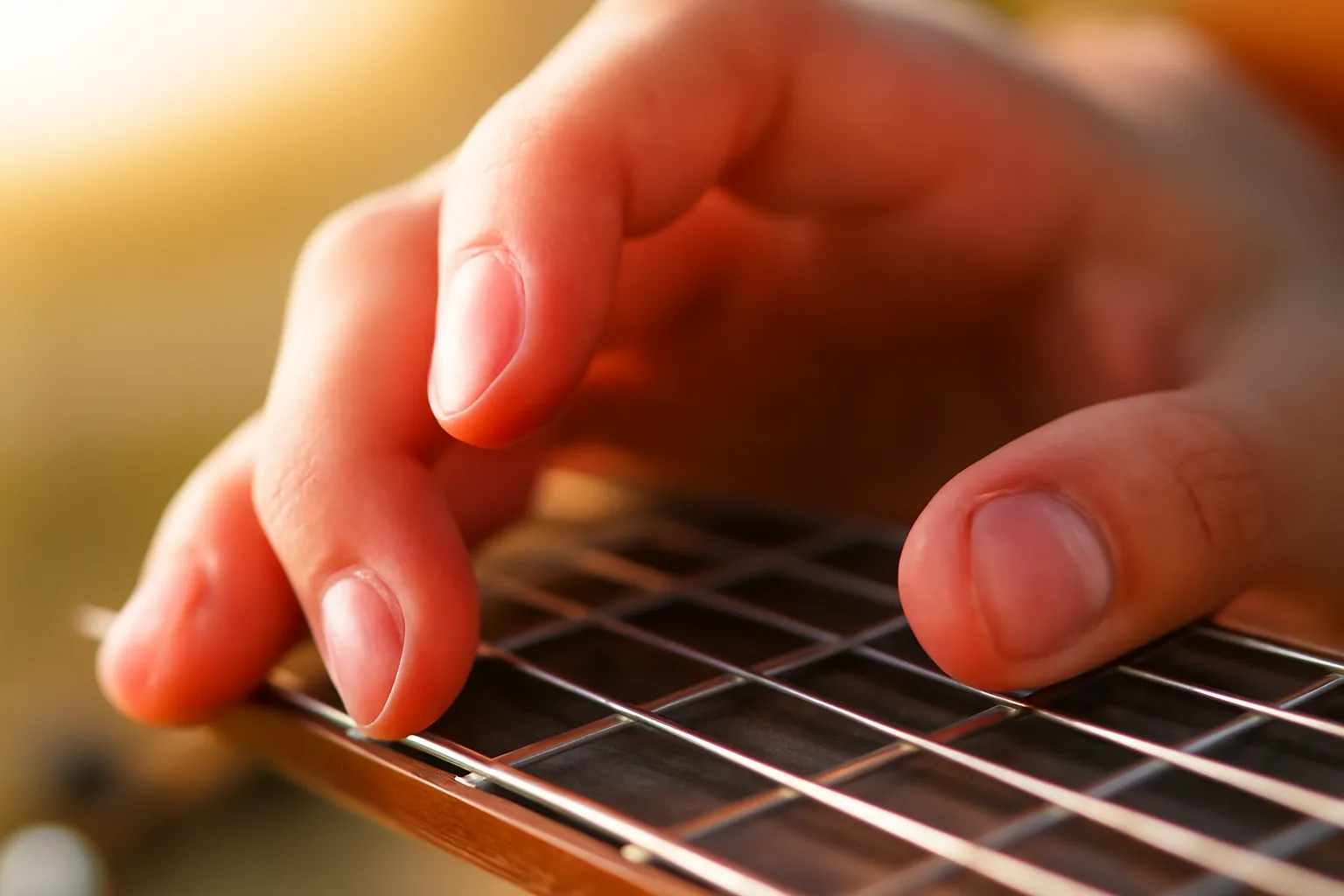 Cận cảnh đầu ngón tay ấn dây guitar trên cần đàn